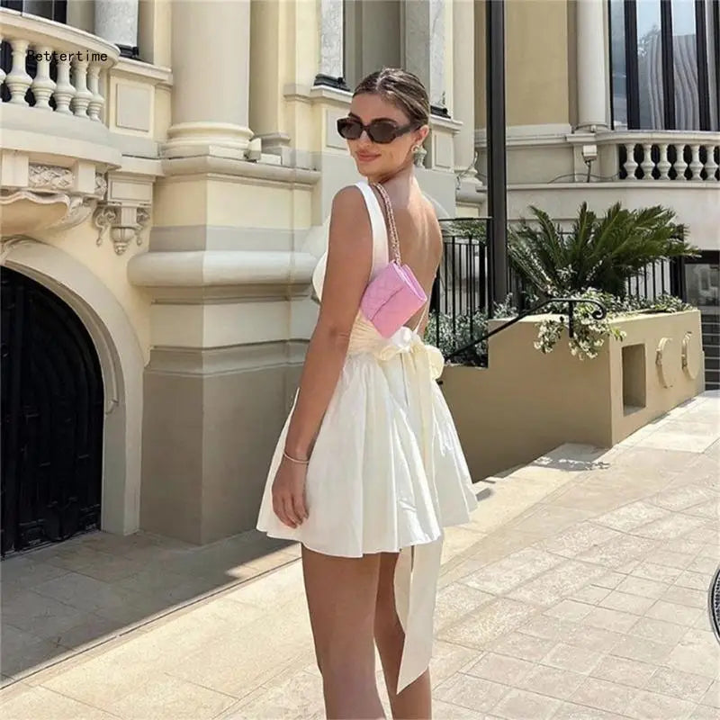 Vestido elegante feminino KLV branco com laço nas costas e bolsa rosa, ideal para ocasiões especiais