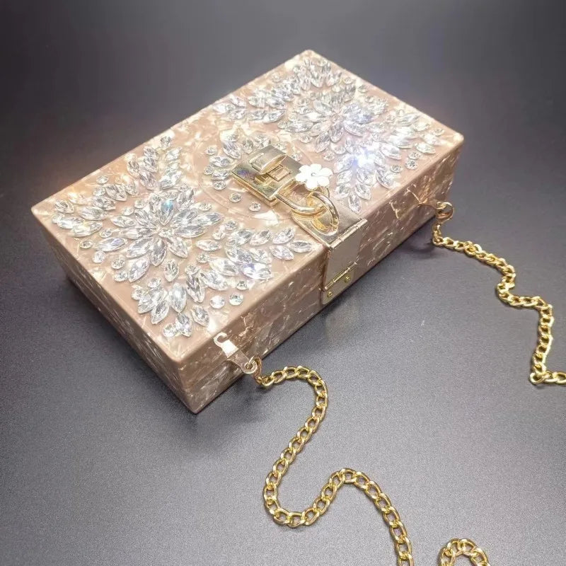 Bolsa clutch casamento em tom nude com detalhes em strass e corrente dourada removível