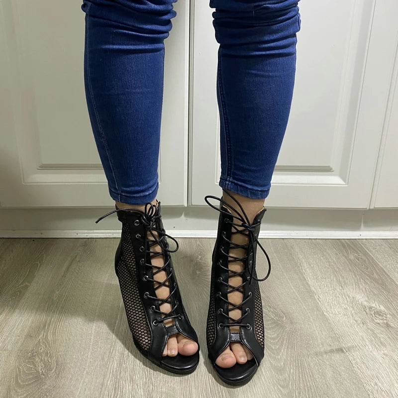 Botas peep toe femininas pretas com cadarço e detalhe em tela combinando com jeans azul