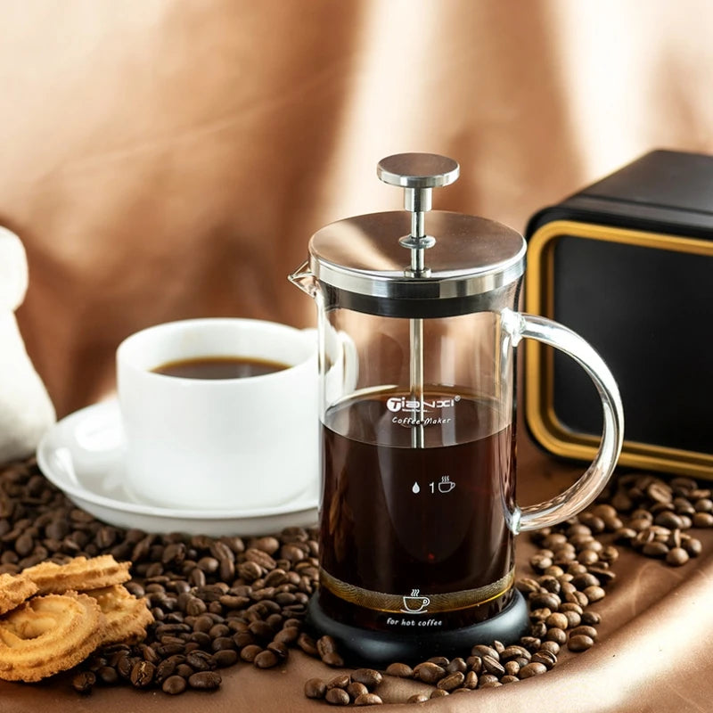 Prensa francesa de café GIANXI em vidro resistente com café fresco ao lado de uma caneca branca