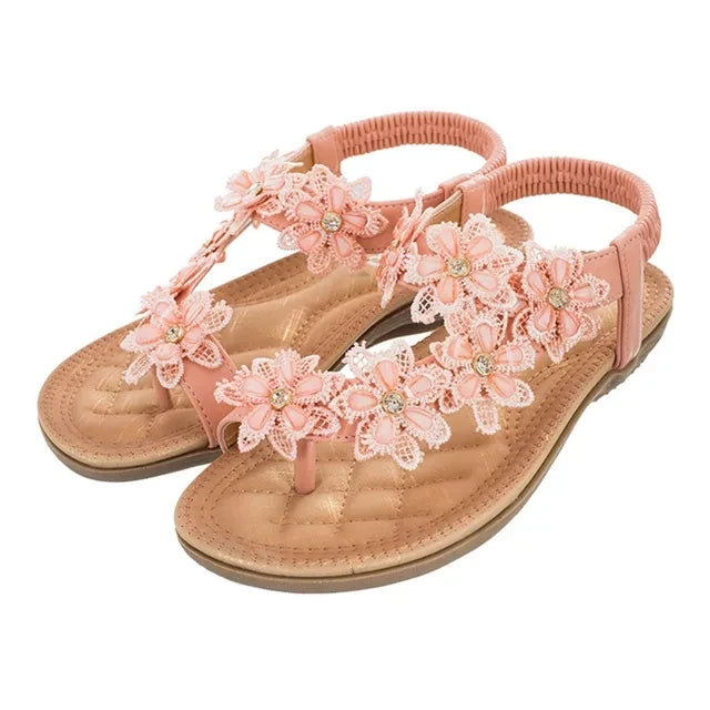 Sandálias femininas com flores em tom rosa, detalhes em crochê e pedrarias para um visual elegante e confortável