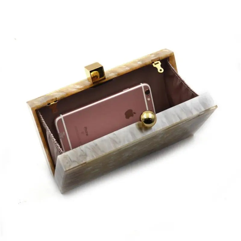 Clutch bege de luxo aberta mostrando espaço para um celular e detalhes elegantes internos