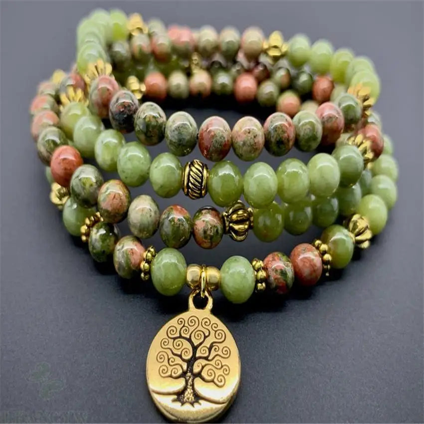 Colar japamala de jade com contas verdes e douradas, adornado com pingente de árvore da vida.