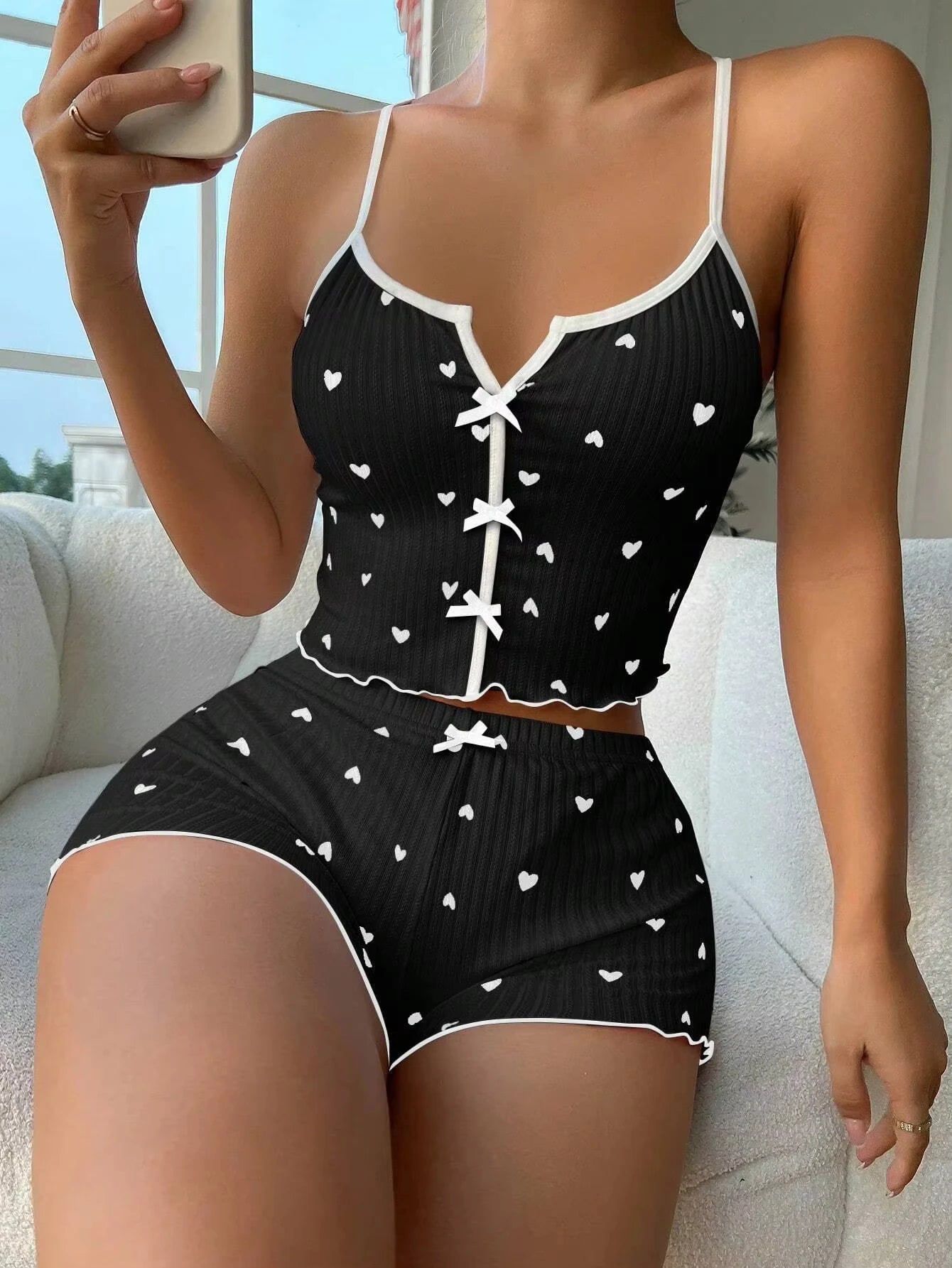 Conjunto pijama fofo arco frontal em preto com corações brancos, ideal para conforto e estilo em casa.