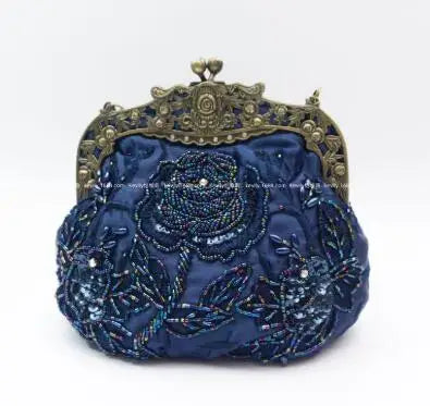 Bolsa feminina vintage em azul escuro com bordados florais e fecho dourado elegante