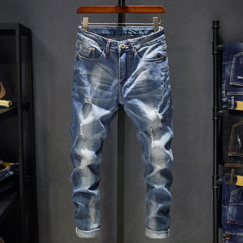 Calça masculina jeans rasgado azul claro da marca CASTUN com detalhes desfiados e acabamento moderno