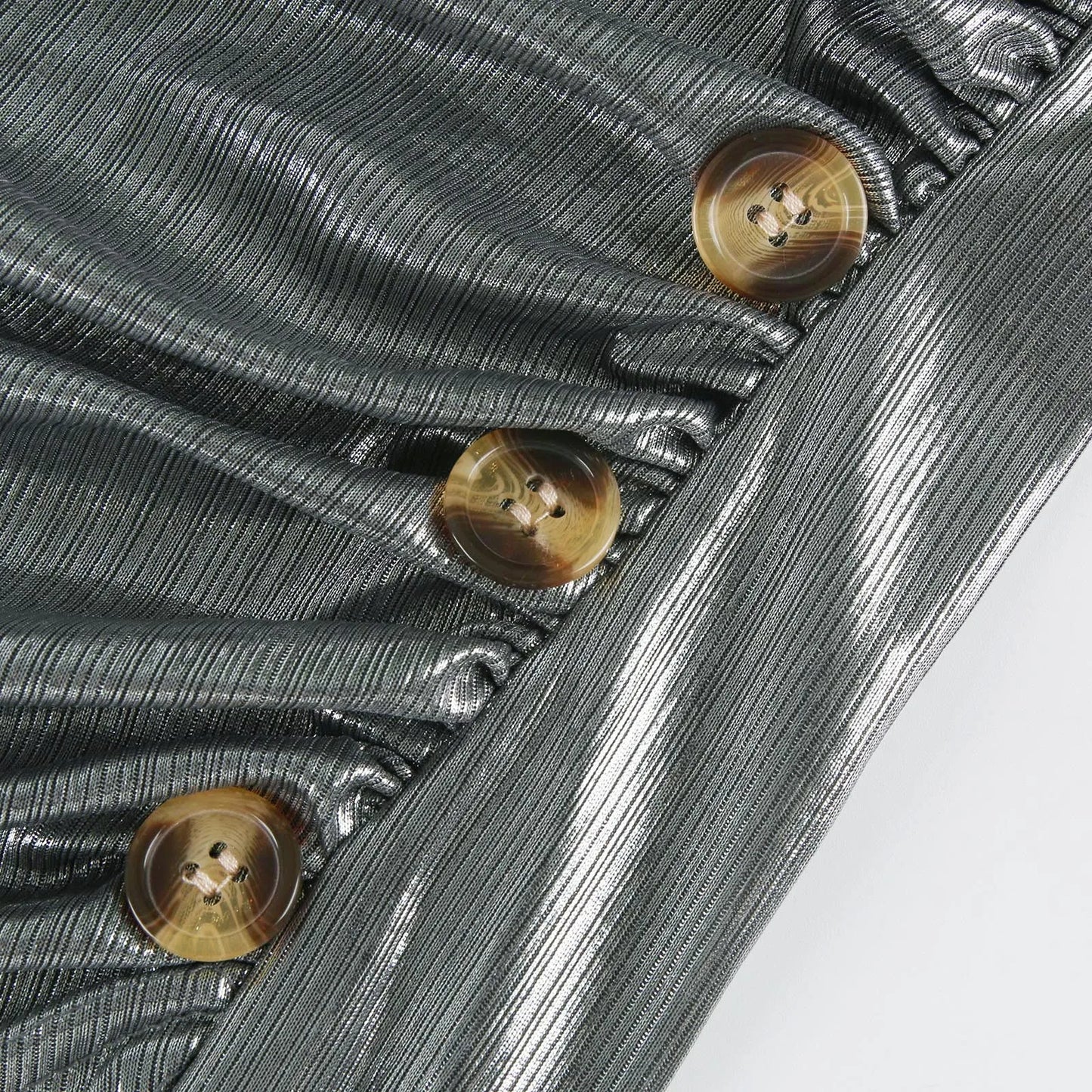Detalhe de mini vestido sexy com botões e tecido brilhante em tom cinza