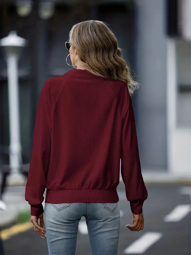 Moletom feminino solto na cor bordô, com mangas longas e ajuste na barra, ideal para looks casuais.
