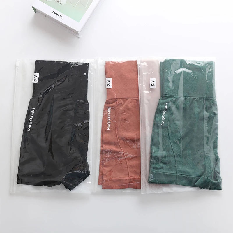 Conjunto de shorts sem costura feminino em preto, terracota e verde, embalados para fácil armazenamento