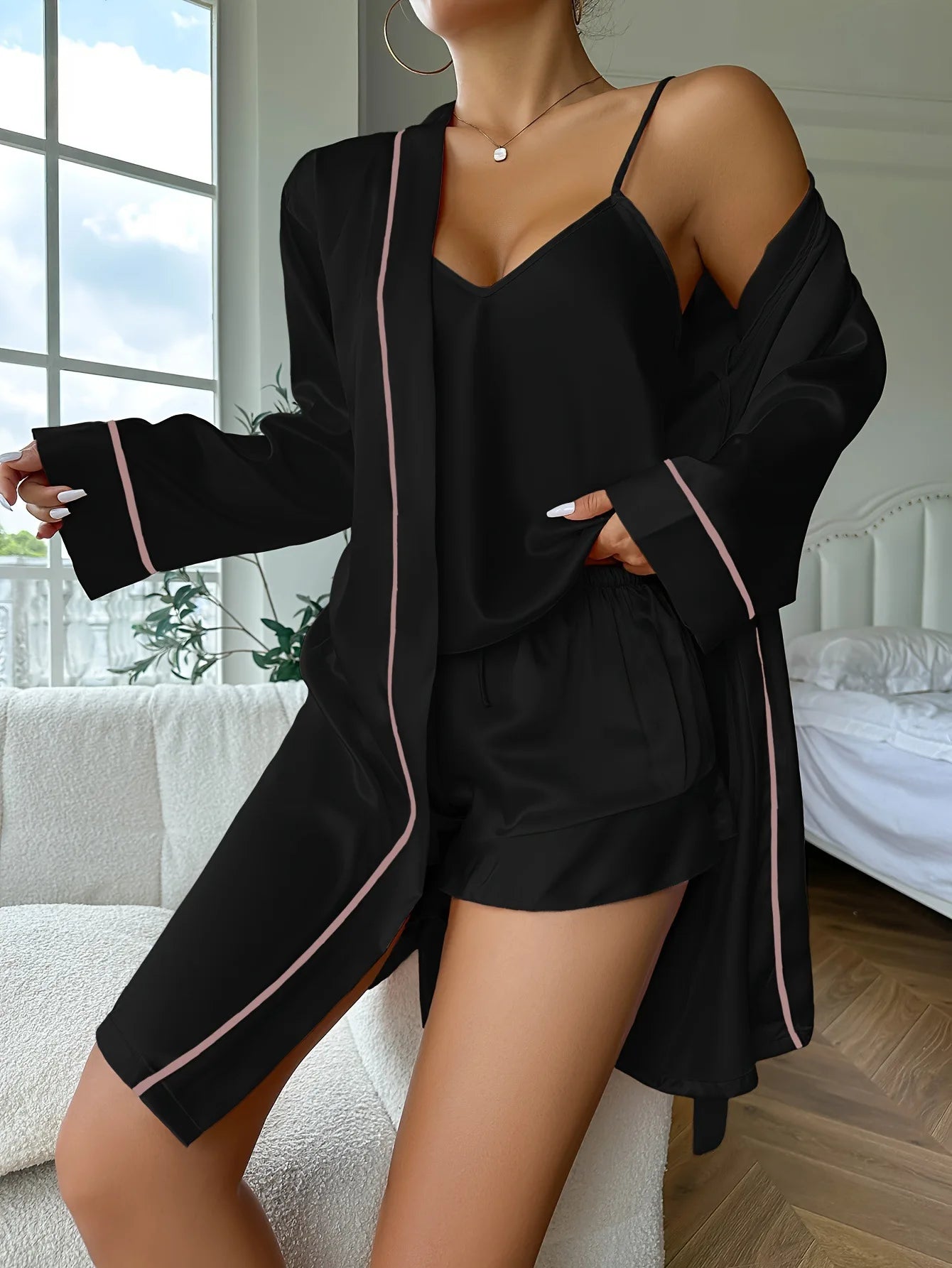Conjunto de pijamas feminino cetim elegante em preto com detalhes em rosa, ideal para noites confortáveis.