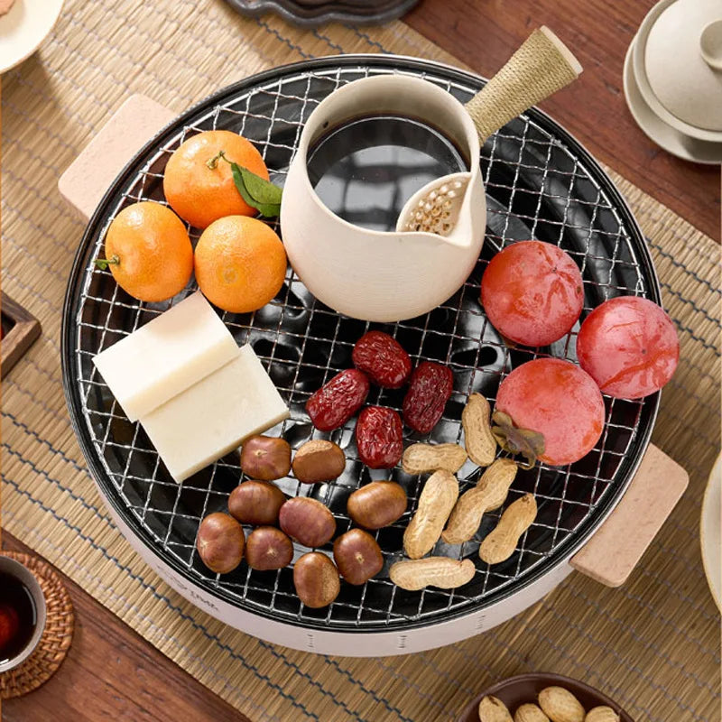 Fogão a carvão com rack de churrasco isolado e pratos de frutas e aperitivos variados