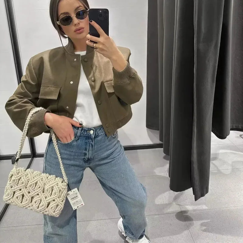 Jaqueta bomber feminina TRAF em tom verde oliva combinada com camiseta branca e jeans largo