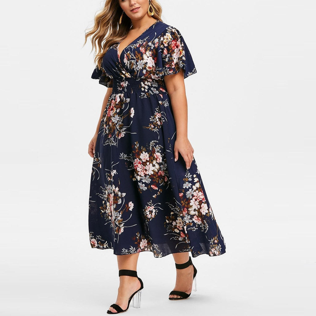Vestido plus size floral em fundo azul com mangas soltas e detalhes em flores coloridas
