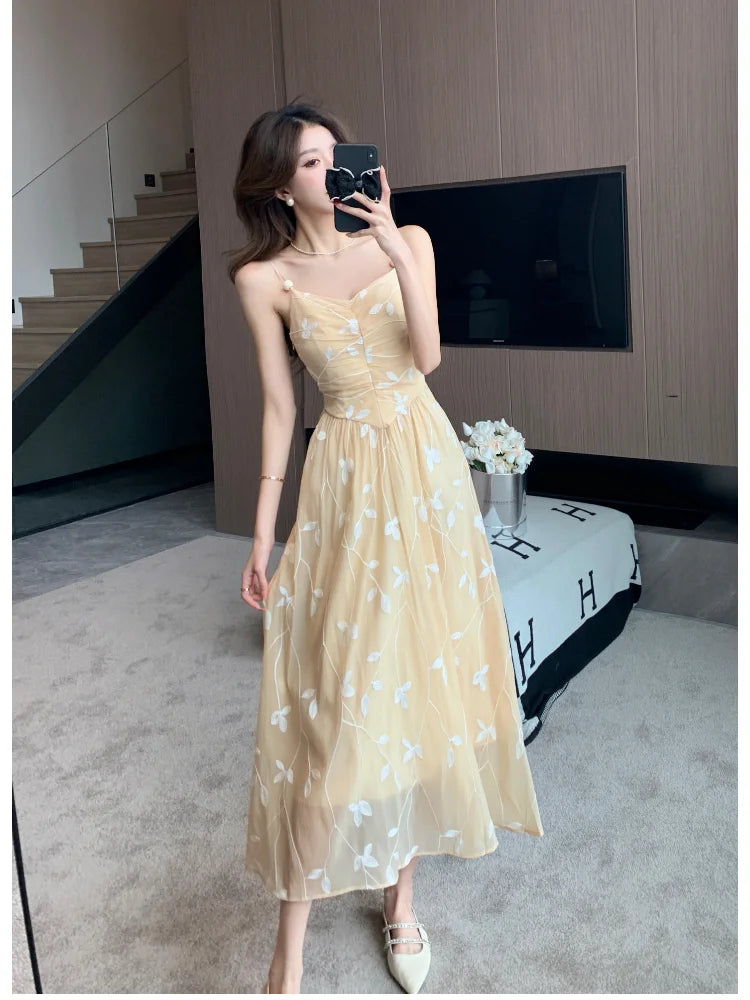 Vestido sem costas elegante em amarelo com detalhes florais, ideal para eventos especiais