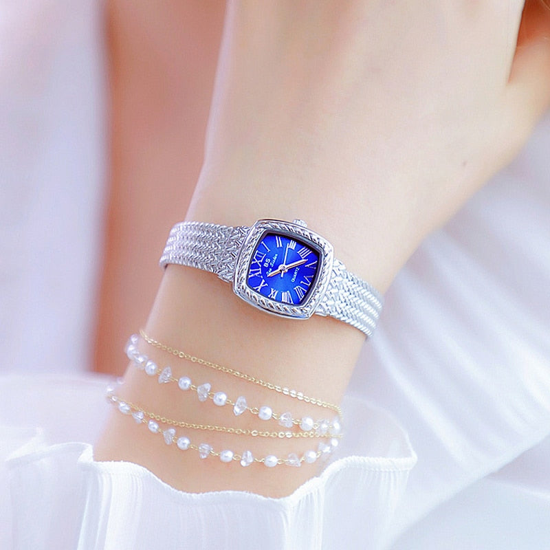 Relógio feminino dourado com pulseira prateada e mostrador azul, estilo elegante para uso diário
