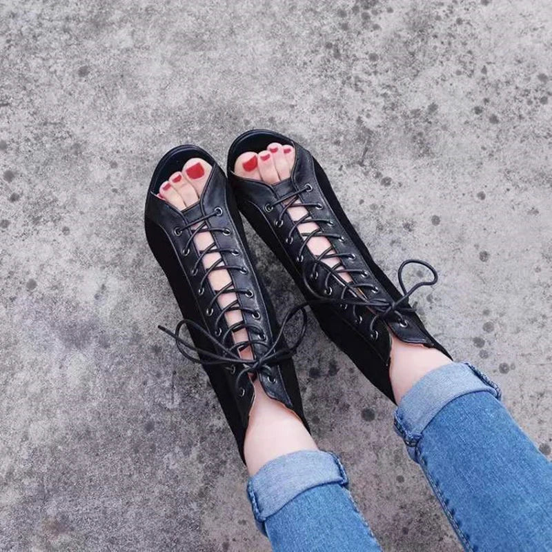 Botas femininas salto alto preto com design aberto e amarração frontal usadas com jeans