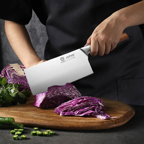 Facas de chef profissional cortando repolho roxo em uma tábua de madeira com um chef