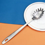 Colher concha escumadeira de aço inoxidável sobre um prato branco em fundo colorido