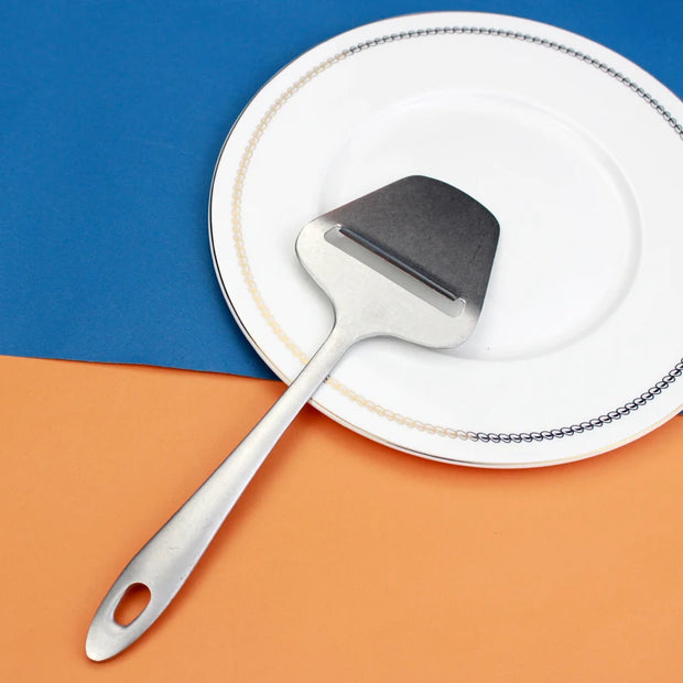 Colher concha escumadeira LUCF em inox com design moderno em fundo de pratos brancos