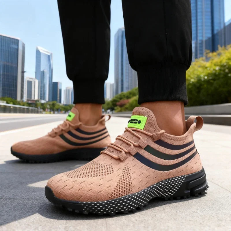 Sapatos de malha antiderrapante para homem em tom nude com detalhes em preto e verde, ideal para conforto e estilo.